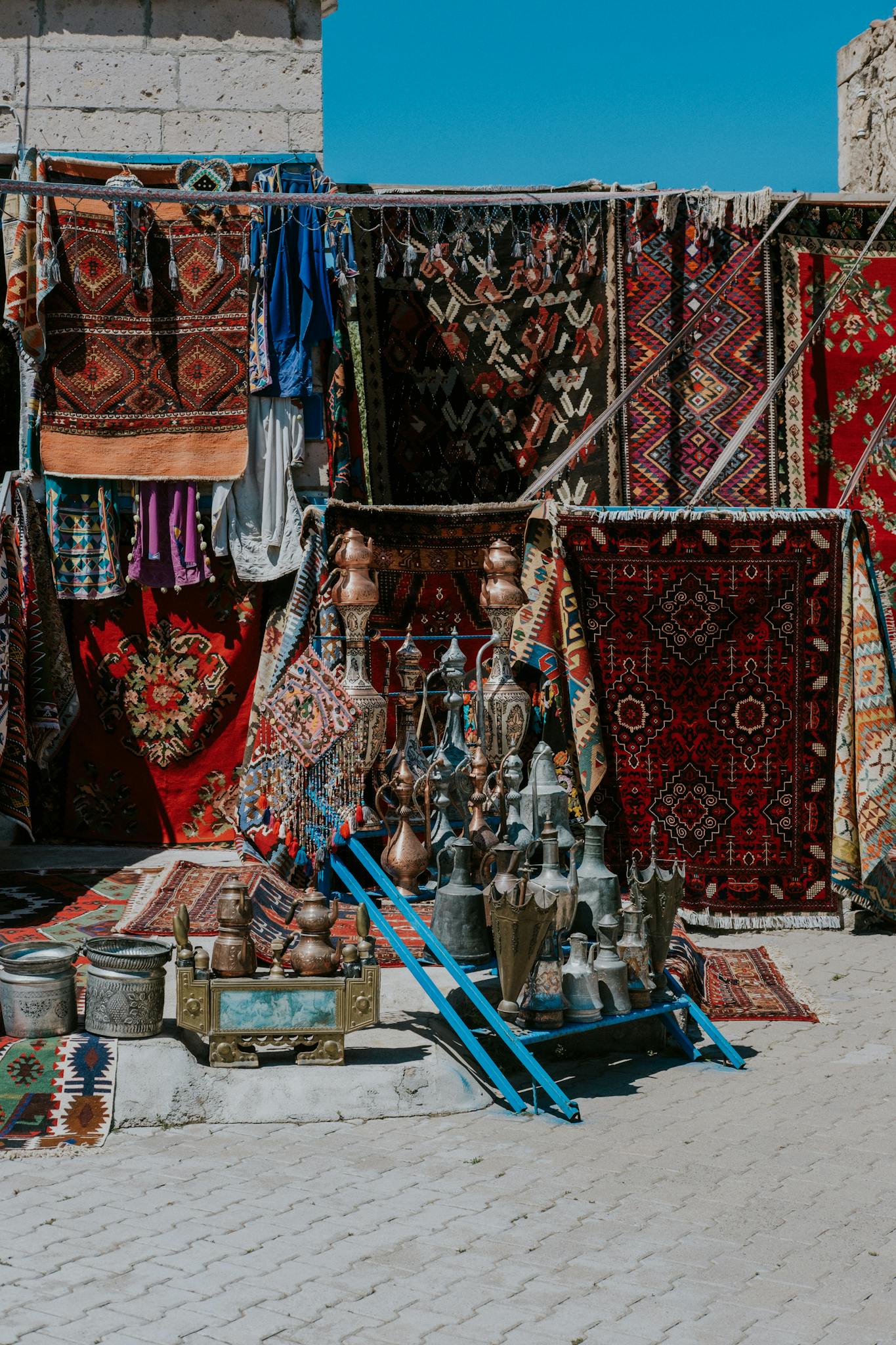 Vibrant outdoor Turkish bazaar showcasing colorful carpets and traditional artifacts.